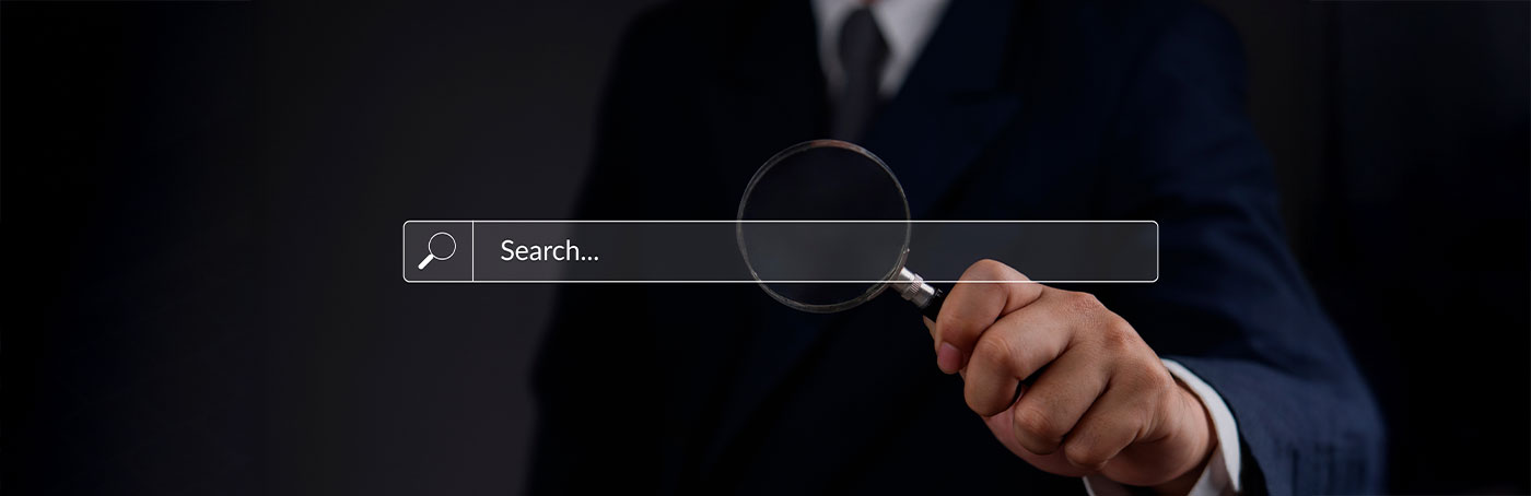 Image of a search bar with a man holding a magnifying glass behind it